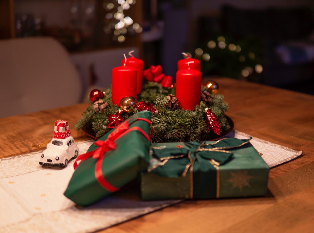 unlighted-red-advent-candles-on-table-beside-green-gift-1746191-1024x762.jpg.optimal.jpg